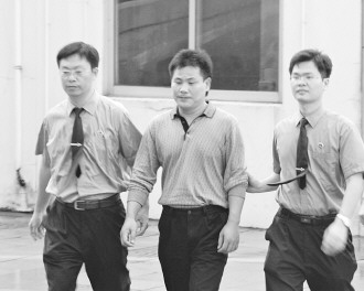 圖為陳建學(xué)被押送接受審訊。吳曉鋒攝