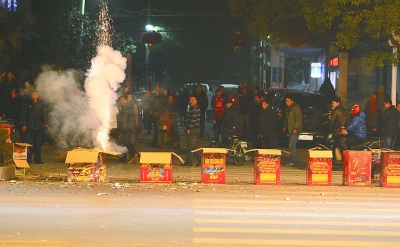 上圖：昨晚7點(diǎn)49分，在漢口建設(shè)大道802號(hào)長(zhǎng)江委酒寶蕩小區(qū)門前的人行橫道上，有人大肆燃放煙花爆竹，硝煙彌漫，空氣污染。 記者金思柳 攝