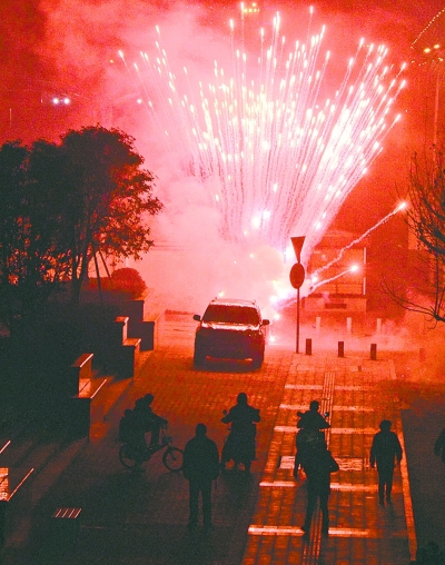 左圖：昨晚8點(diǎn)09分，在武昌徐東大街東段的湖北銀行門前，有人大肆燃放煙花爆竹，不少行人望而卻步。 記者金思柳 攝