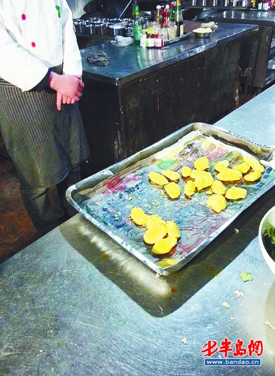 小漁村海鮮碼頭酒店將炸好的山藥放在報紙上。